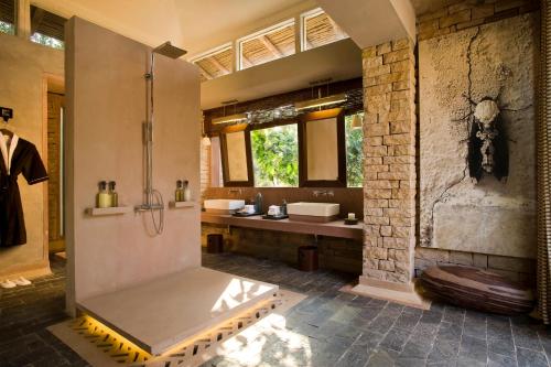 a large bathroom with a shower and a sink at Pashan Garh Panna National Park - A Taj Safari Lodge in Panna