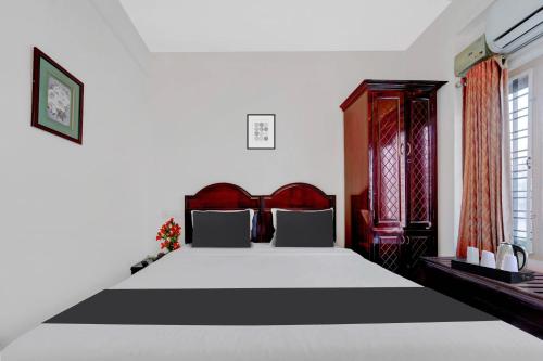 a bedroom with a large bed and red curtains at Super Collection O Chalai Bazaar Near Railway Station formerly Galaxy Inn in Trivandrum