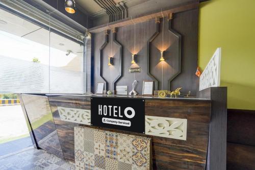 a hotel counter with a sign on the wall at Super Hotel O Subedarganj Railway Junction Formerly Krishna Inn in Prayagraj