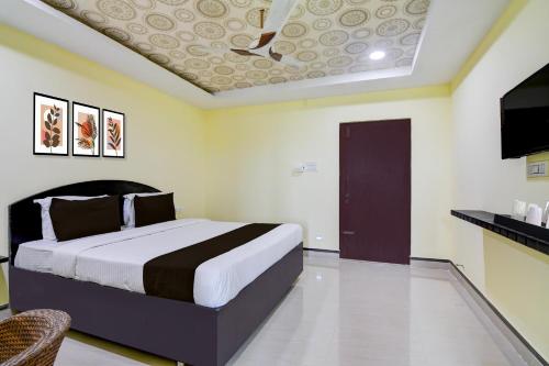 a bedroom with a large bed in a room at Super Collection O Rama Lakshmana Junction Srikakulam in Srīkākulam
