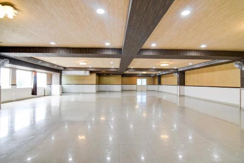 a large empty room with a white floor and a wooden ceiling at Super Collection O Rama Lakshmana Junction Srikakulam in Srīkākulam