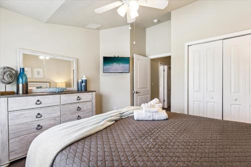 a bedroom with a large bed with a dresser and a mirror at Cape Crossing 103 in Merritt Island