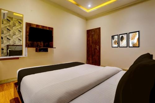a bedroom with a bed and a flat screen tv at Super Collection O Shri Sai Baba Temple Formerly Hotel Maitreya in Shirdi