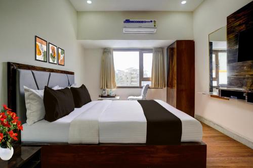 a bedroom with a large bed and a window at Super Collection O Shri Sai Baba Temple Formerly Hotel Maitreya in Shirdi