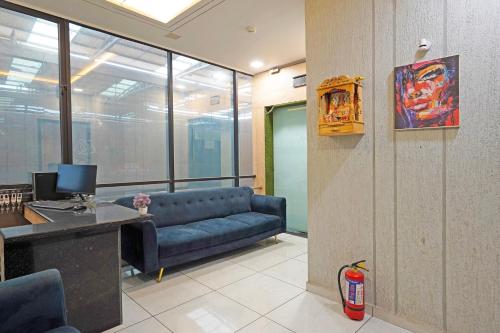 a living room with a blue couch in an office at Super Hotel O Ugat Canal Surat Formerly Royal Orbit in Rānder