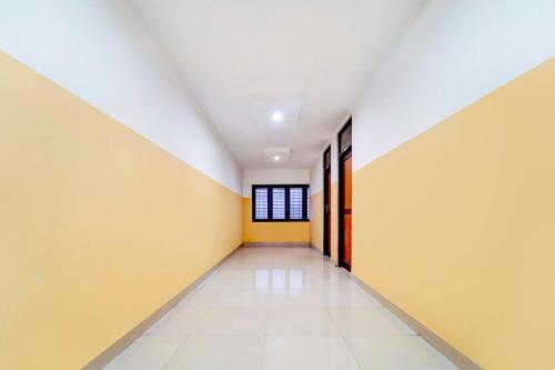an empty hallway with yellow and white walls at Super Hotel O Kunnamangalam Near Bus Stand in Calicut