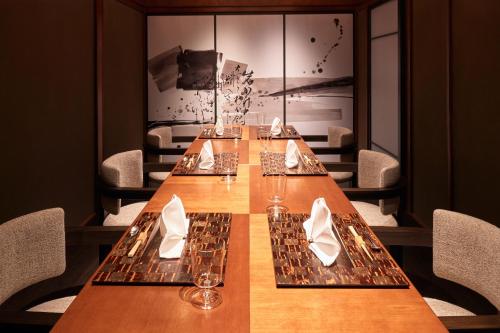 a long wooden table in a restaurant with chairs at Ochiairo in Izu