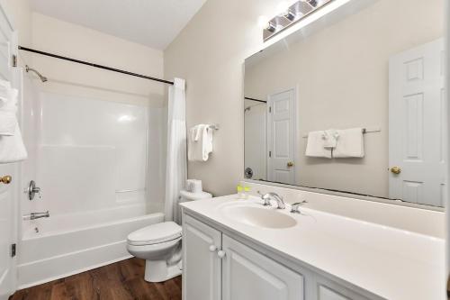 a bathroom with a sink and a toilet and a mirror at Charming 3-Bedroom Cherry Grove Condo in Myrtle Beach
