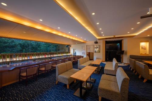 a restaurant with tables and chairs and a bar at Iizaka Onsen Surikamitei Ohtori in Fukushima