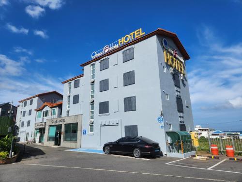 a hotel with a car parked in front of it at Jeju Ocean Family Hotel in Jeju