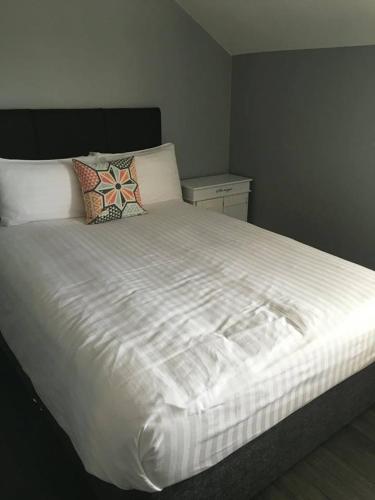 a large white bed with pillows at Dingle Town Center Apartment in Dingle