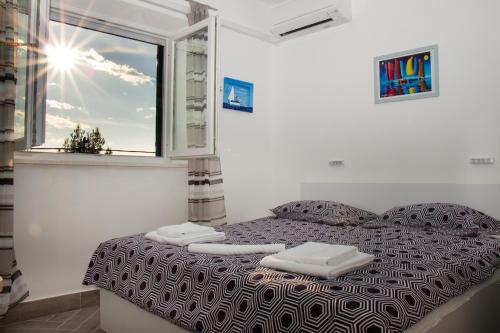 1 dormitorio con cama con almohadas y ventana en Apartment Bava, en Jesenice