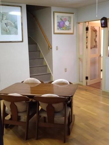 a dining room table with chairs and a staircase at Mount Villa Atami in Kannami