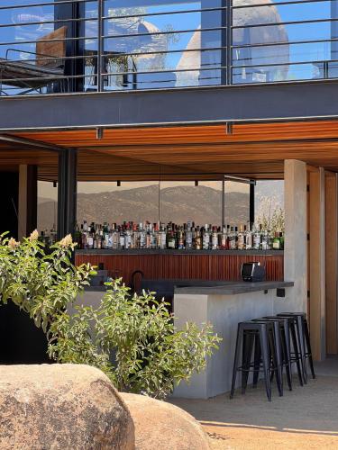 un bar avec des tabourets de bar devant un bâtiment dans l'établissement Casa Gracia Valle de Guadalupe, à El Sauzal