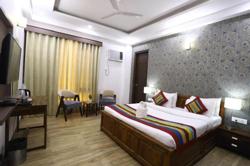 古尔冈Corporate Prime Stay的配有床、书桌和电视的酒店房间