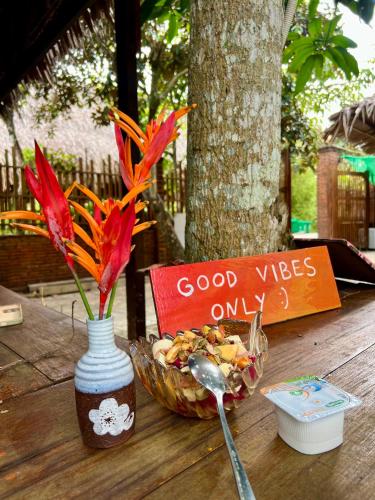 Ấp Nhơn BìnhMuong Dinh Lodge的一个花瓶，里面有一碗食物和一碗花