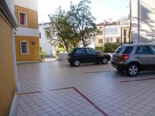 two cars parked in a parking lot next to a building at Hotel Minerva in Pordenone