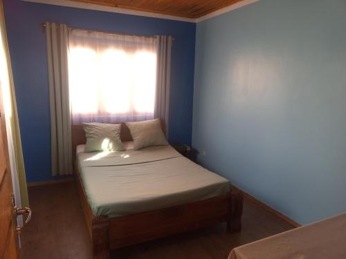 a small bed in a room with a window at Rosaria in Antananarivo