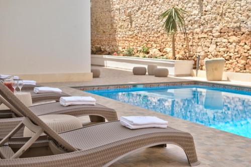 a hotel pool with lounge chairs and a swimming pool at Palazzo Violetta in Sliema