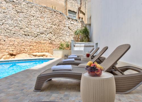 a group of chairs sitting next to a swimming pool at Palazzo Violetta in Sliema
