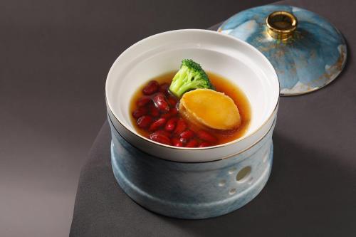 a bowl of food with broccoli and fruit in it at Holiday Inn Fuzhou Exhibition Center in Fuzhou