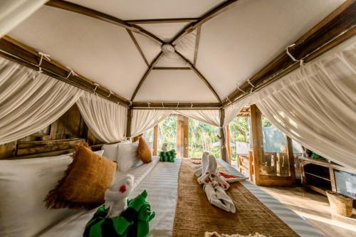 a room with a bed with stuffed animals on it at Sunsura Villas in Nusa Penida