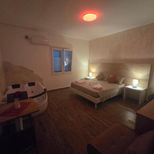 a bedroom with a bed and two tables and a couch at Miluna Affittacamere in Siniscola
