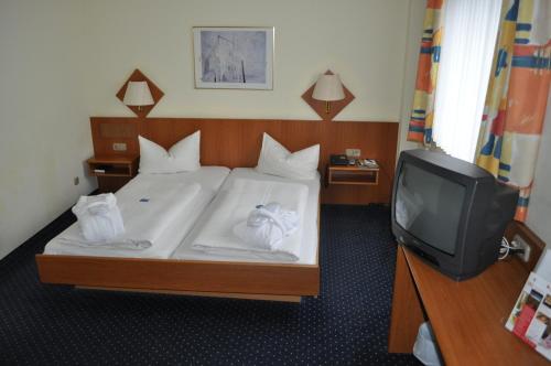a hotel room with a bed and a tv at Fly Inn Hotel Frankfurt Airport Rüsselsheim ehemals Trip Inn Hotels in Rüsselsheim