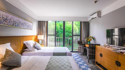um quarto de hotel com duas camas e uma janela em Yangshuo Courtyard Hotel - An all-English team by the Li River em Yangshuo