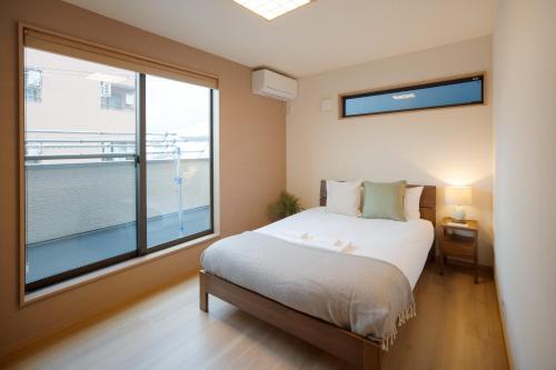 a bedroom with a bed and a large window at 静和 旅タイム岸里美楽 in Osaka