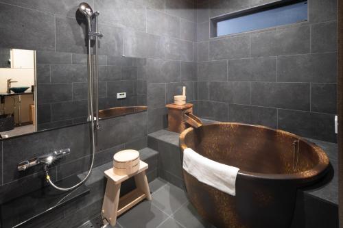a bathroom with a wooden tub and a shower at 静和 旅タイム岸里美楽 in Osaka