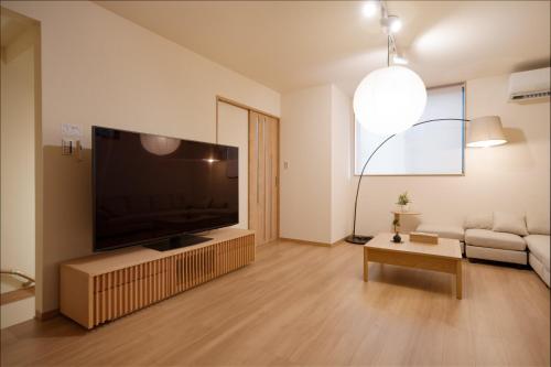 a living room with a large flat screen tv at 静和 旅タイム岸里美楽 in Osaka