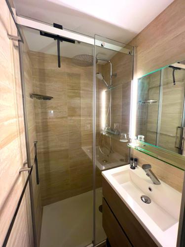 a bathroom with a glass shower and a sink at Sea Front in La Ciotat