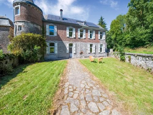 an old brick house with a grass yard in front of it at Castle in Ferrières with Pond Garden in Ferrières