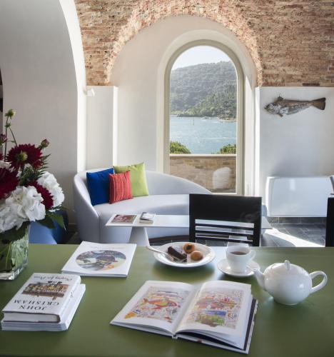 a living room with a table with books and a couch at Grand Hotel Portovenere in Portovenere