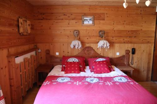 een slaapkamer met een bed in een blokhut bij Hôtel de la Poste in Valloire