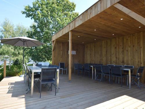 a wooden deck with tables and chairs and an umbrella at Holiday Home in Waimes with Sauna & Bubble Bath in Waimes