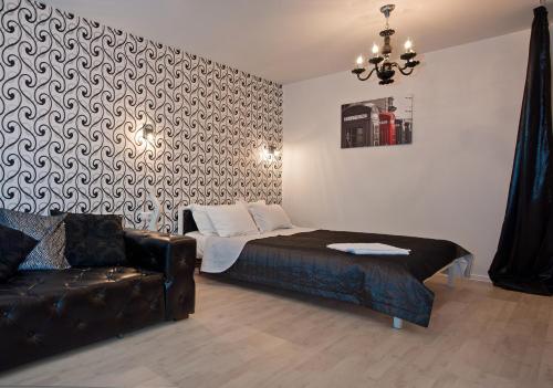 a bedroom with a bed and a couch and a chandelier at Partner Guest House in Kyiv
