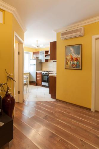a kitchen with yellow walls and a wooden floor at Partner Guest House in Kyiv