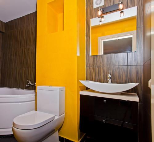 a bathroom with a white toilet and a sink at Partner Guest House in Kyiv