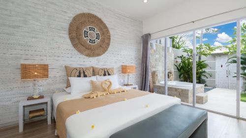 ein Schlafzimmer mit einem großen Bett und einem großen Fenster in der Unterkunft Villa Larimar by Villa Finder in Legian