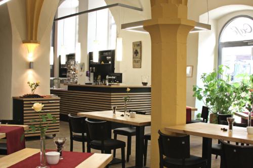 un ristorante con tavoli e sedie e un bar di Augustinerkloster Gotha Herberge gGmbH a Gotha