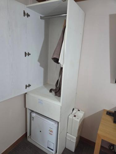 a small kitchen with a white cabinet and a refrigerator at Central Plaza Hotel in Seryu-dong