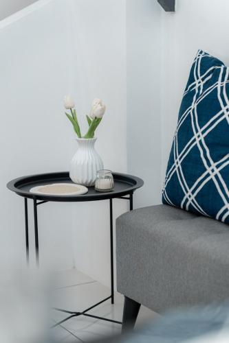 a table with a vase on it next to a couch at VibeHaus Snooker SimpangAmpat ``` 4Room10Pax3Bath in Simpang Ampat