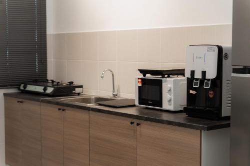 a kitchen with a counter with a sink and a microwave at VibeHaus Snooker SimpangAmpat ``` 4Room10Pax3Bath in Simpang Ampat