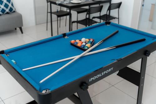 a pool table with cuesticks on top of it at VibeHaus Snooker SimpangAmpat ``` 4Room10Pax3Bath in Simpang Ampat