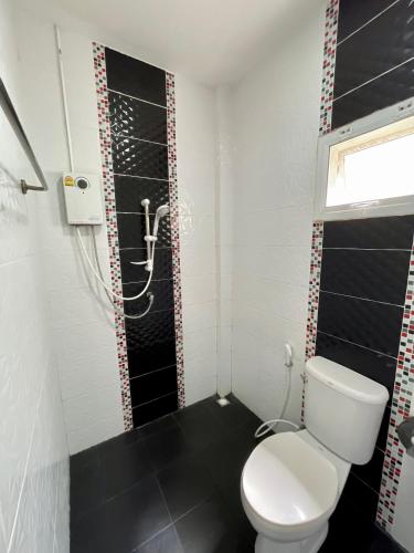 a bathroom with a white toilet and a black floor at P Plus House Ratchaburi in Ban Don Chaeng