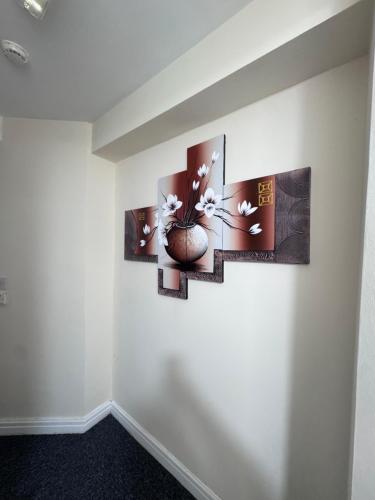 a room with three paintings on the wall at Cozy modern apartment with comfortable living space in Preston