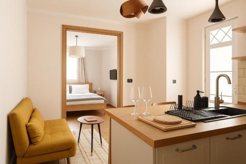 eine Küche mit einer Theke mit einem gelben Stuhl und ein Schlafzimmer in der Unterkunft Dandy Downtown Apt in Budapest