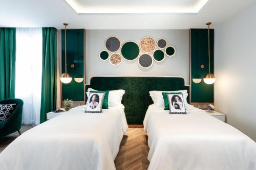 two beds in a room with green walls at La Seine Hotel in Vientiane